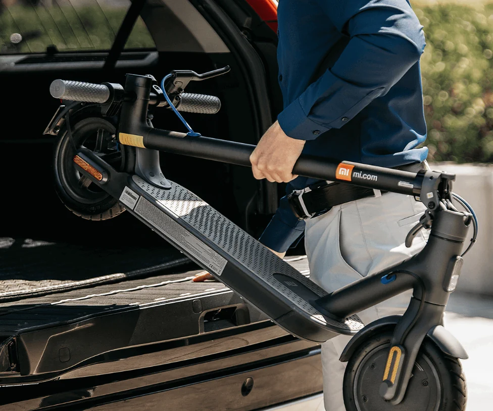 Patinetes eléctrico XiaoMi plegado y a punto de ser montado en el maletero de un coche